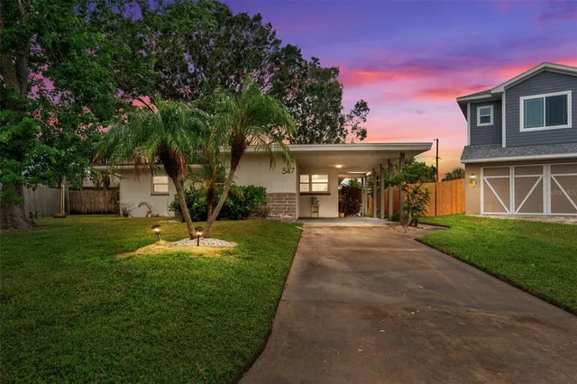 a view of a house with backyard and a tree