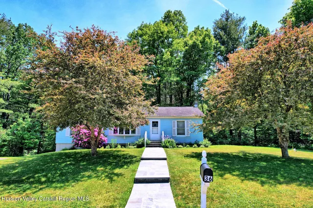 a front view of a house with yard swimming pool and green space