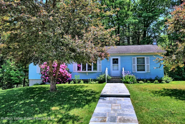 a view of a house with a yard and potted plants