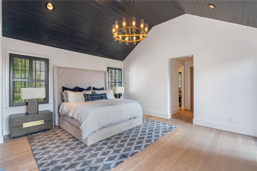 6570 Five Oaks Road Cumming, GA 30040 - Photo 56 of 136 a bedroom with a large bed and a chandelier