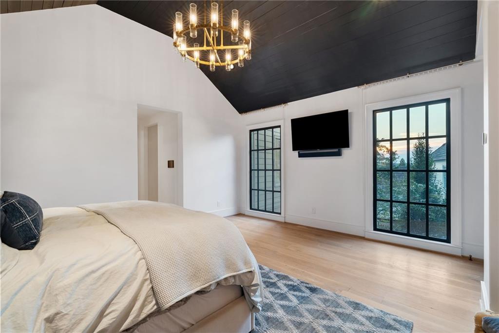 6570 Five Oaks Road Cumming, GA 30040 - Photo 58 of 136 a spacious bedroom with a bed and a flat screen tv