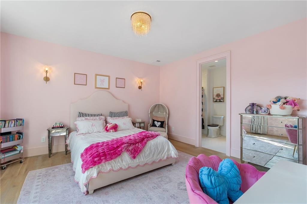 6570 Five Oaks Road Cumming, GA 30040 - Photo 68 of 136 a bedroom with a bed and a chandelier