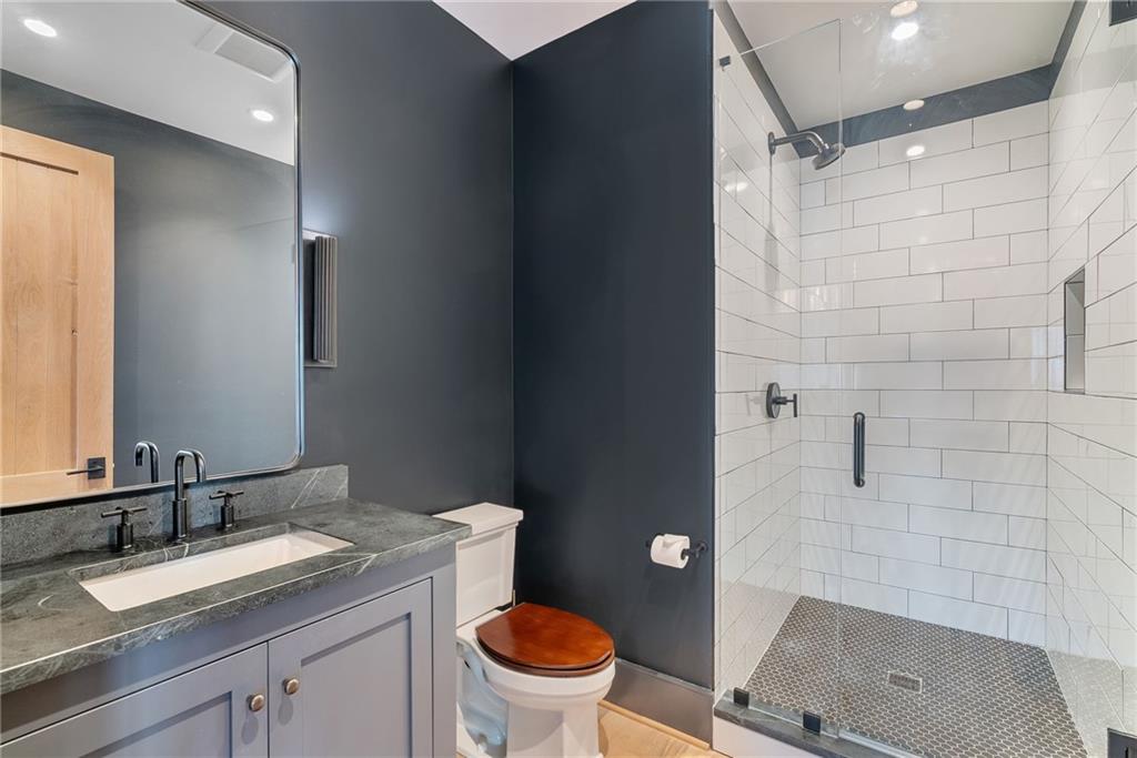 6570 Five Oaks Road Cumming, GA 30040 - Photo 80 of 136 a bathroom with a granite countertop sink toilet mirror and shower