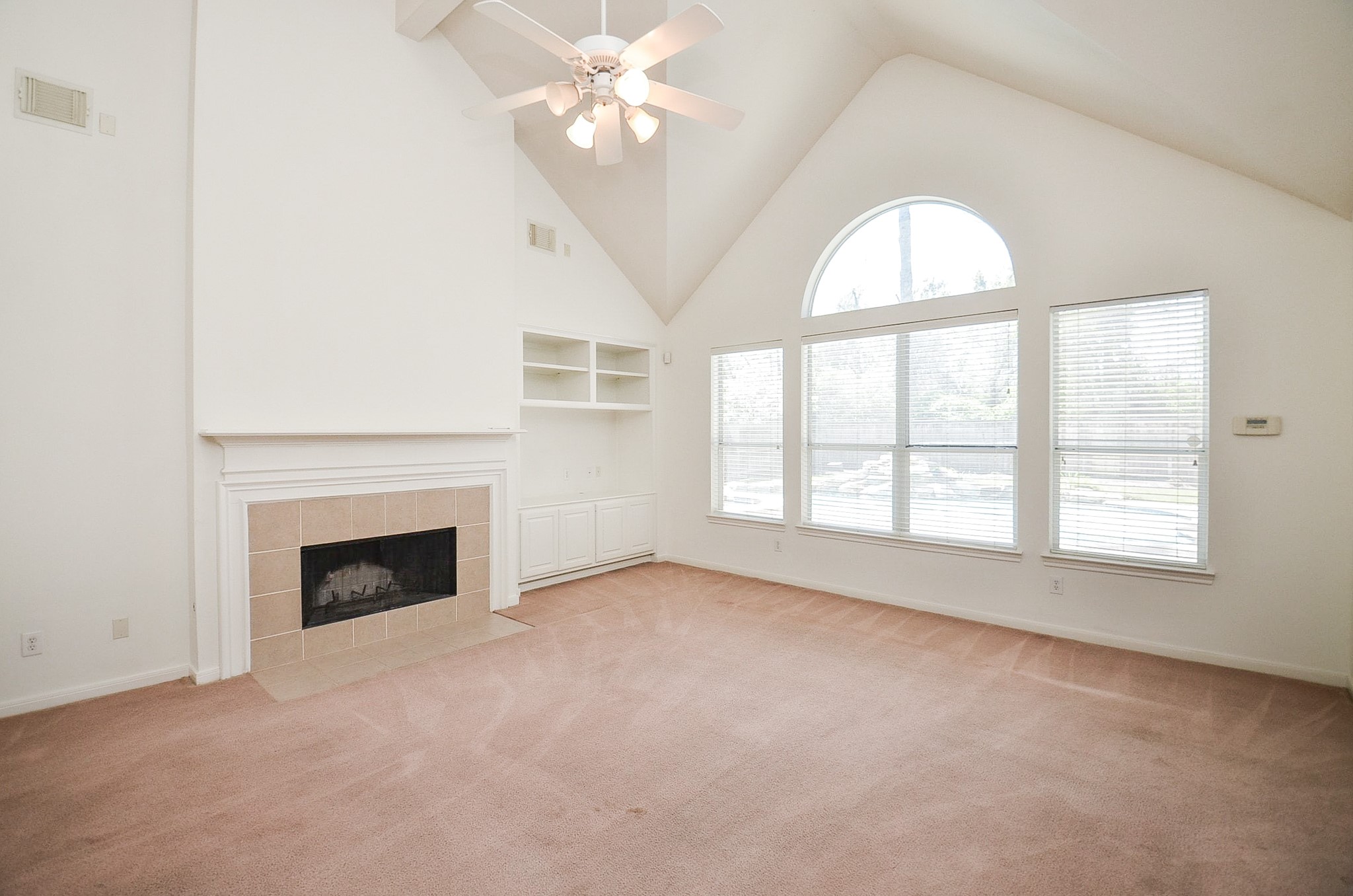 23615 Banning Point Court Katy, TX 77494 - Photo 14 of 50 an empty room with windows chandelier fan and fireplace