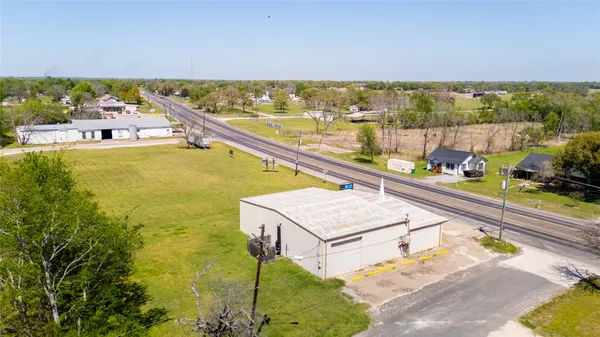 a view of a swimming pool with a chairs and table in the garden