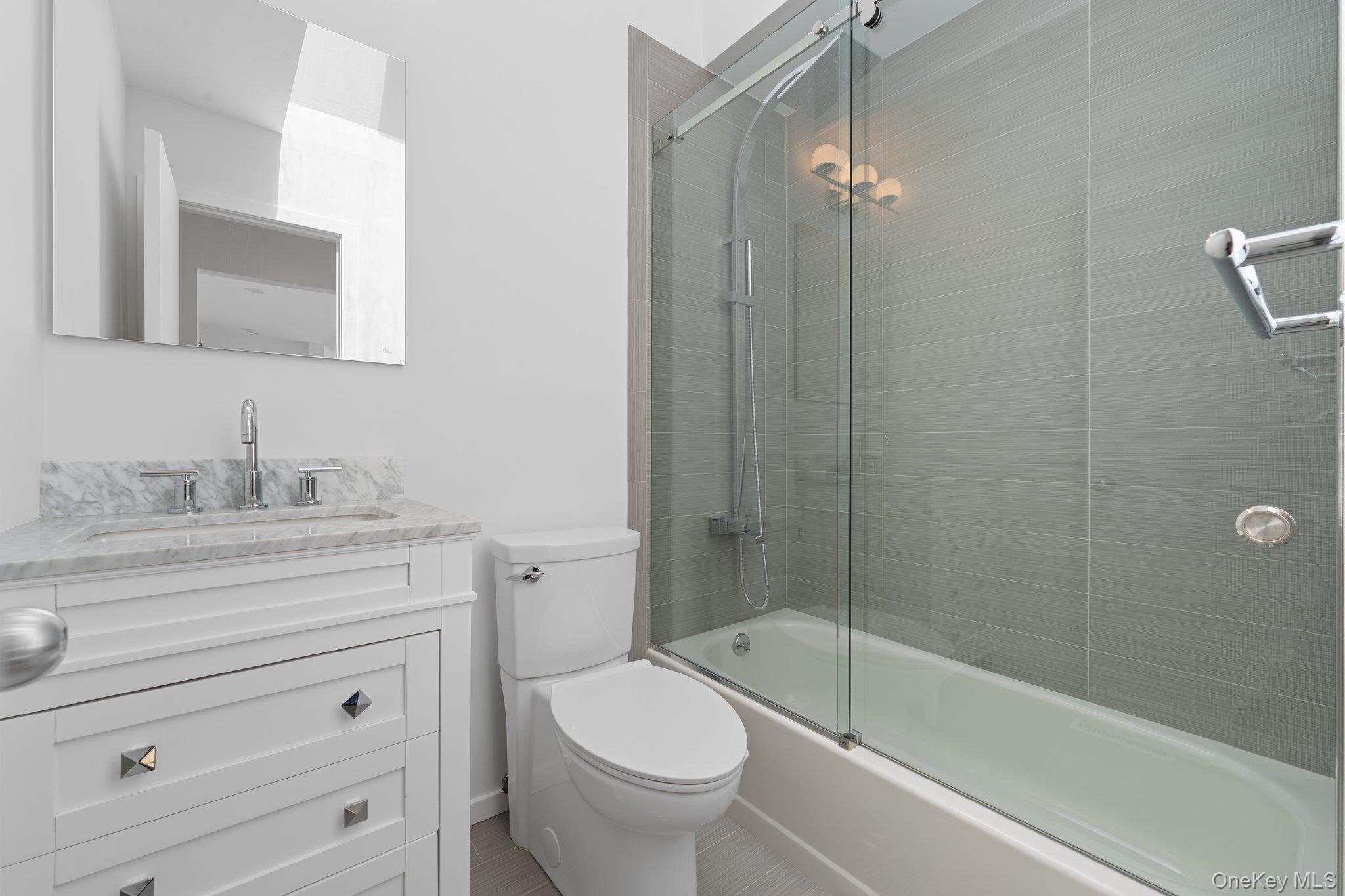 35 Ely Brook Road East Hampton, NY 11937 - Photo 12 of 32 a bathroom with a granite countertop toilet a sink and bathtub