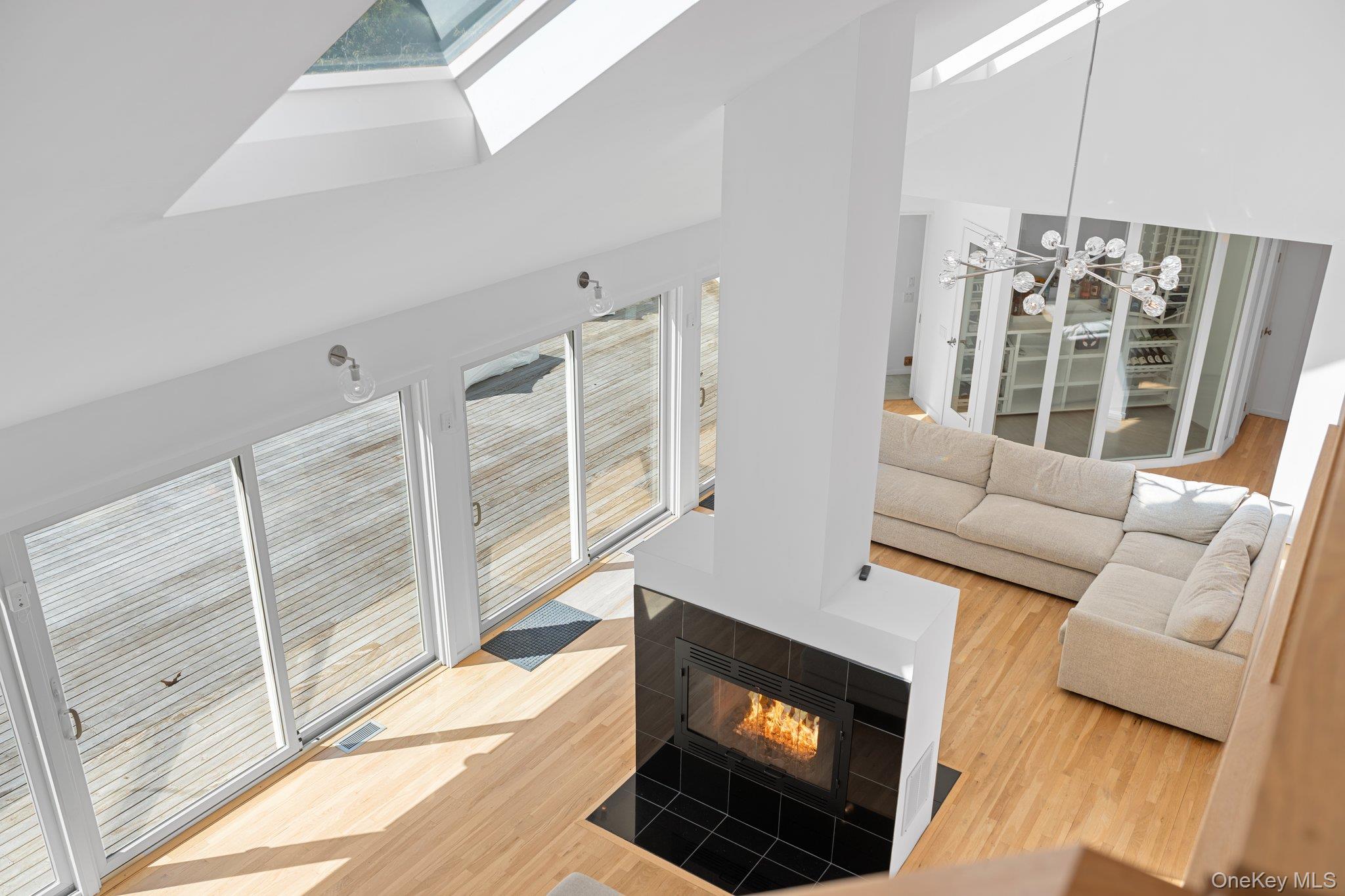 35 Ely Brook Road East Hampton, NY 11937 - Photo 15 of 32 a living room with furniture a flat screen tv and a fireplace