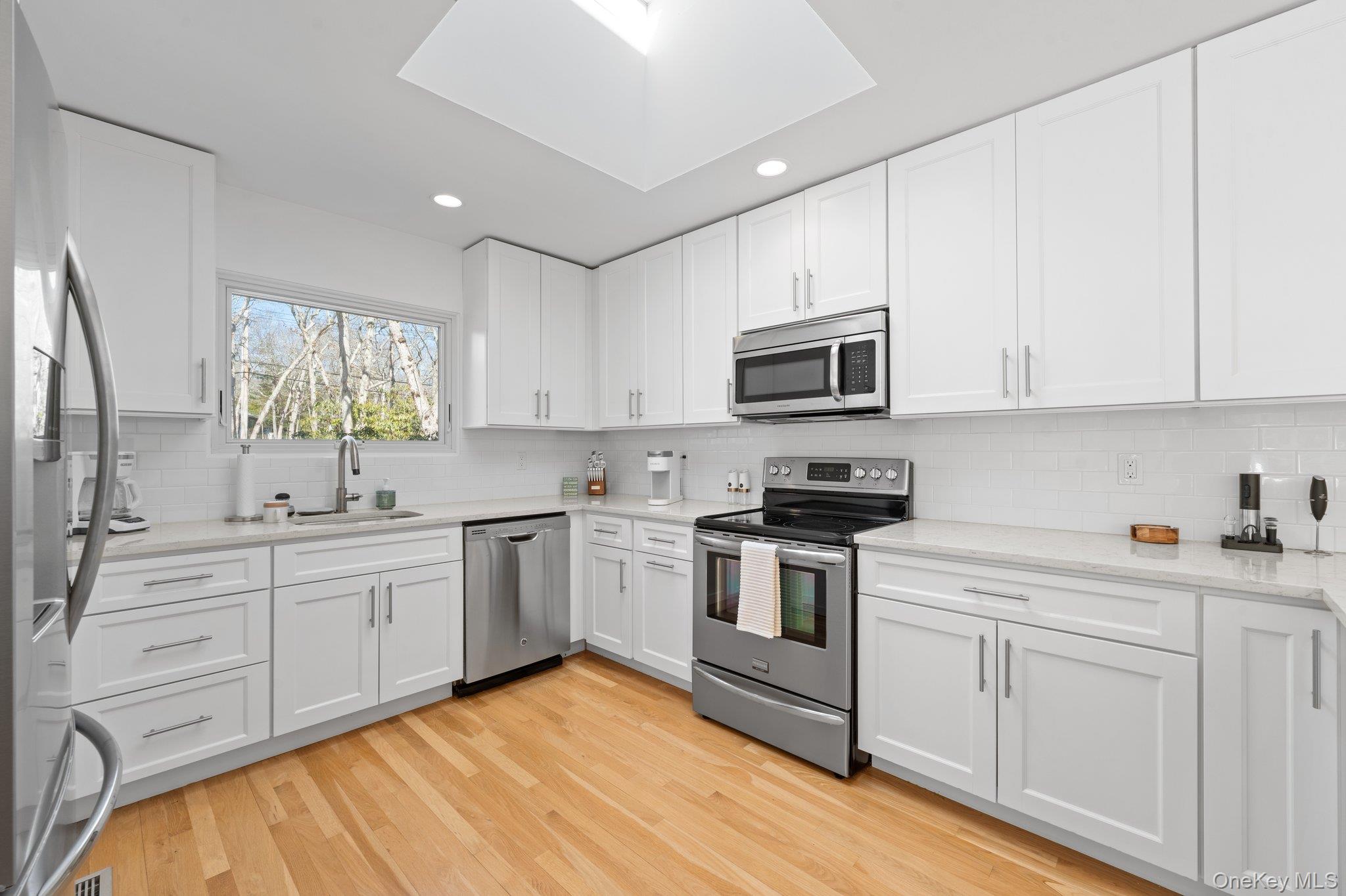 35 Ely Brook Road East Hampton, NY 11937 - Photo 21 of 32 a kitchen with granite countertop white cabinets white stainless steel appliances and a sink