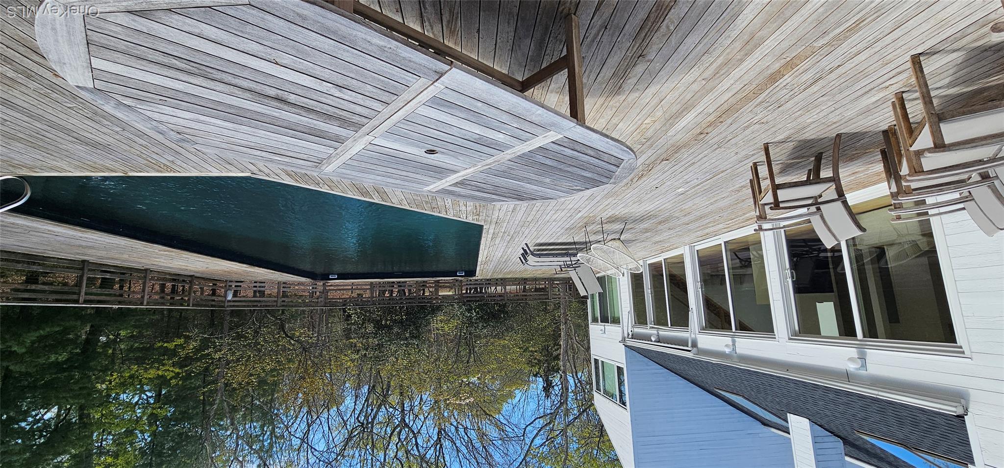 35 Ely Brook Road East Hampton, NY 11937 - Photo 4 of 32 a view of a patio with dining table and chairs with wooden floor