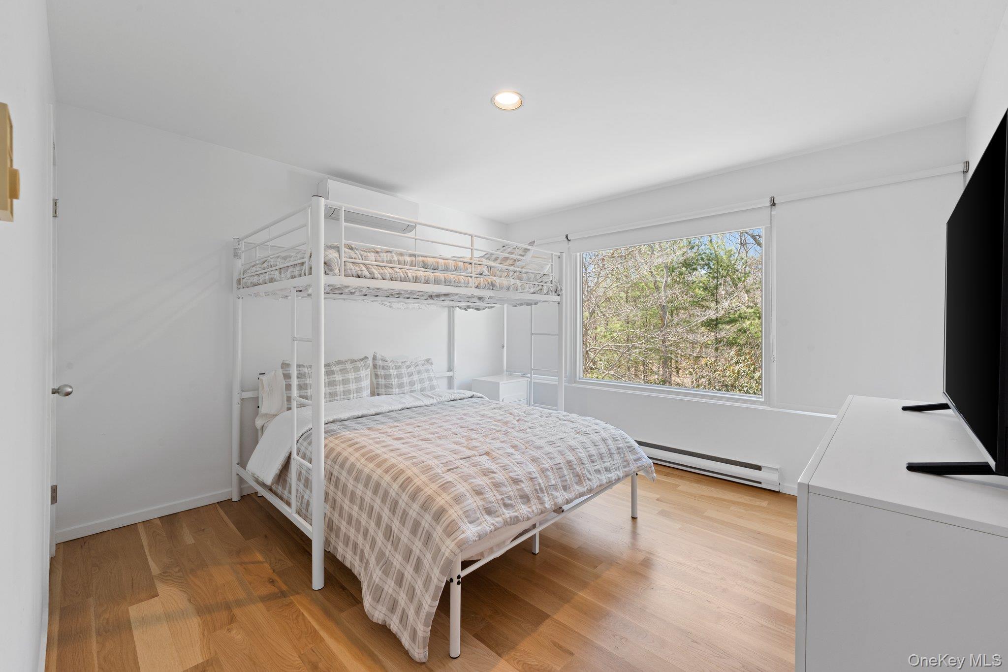 35 Ely Brook Road East Hampton, NY 11937 - Photo 8 of 32 a bedroom with a bed window and a flat screen tv