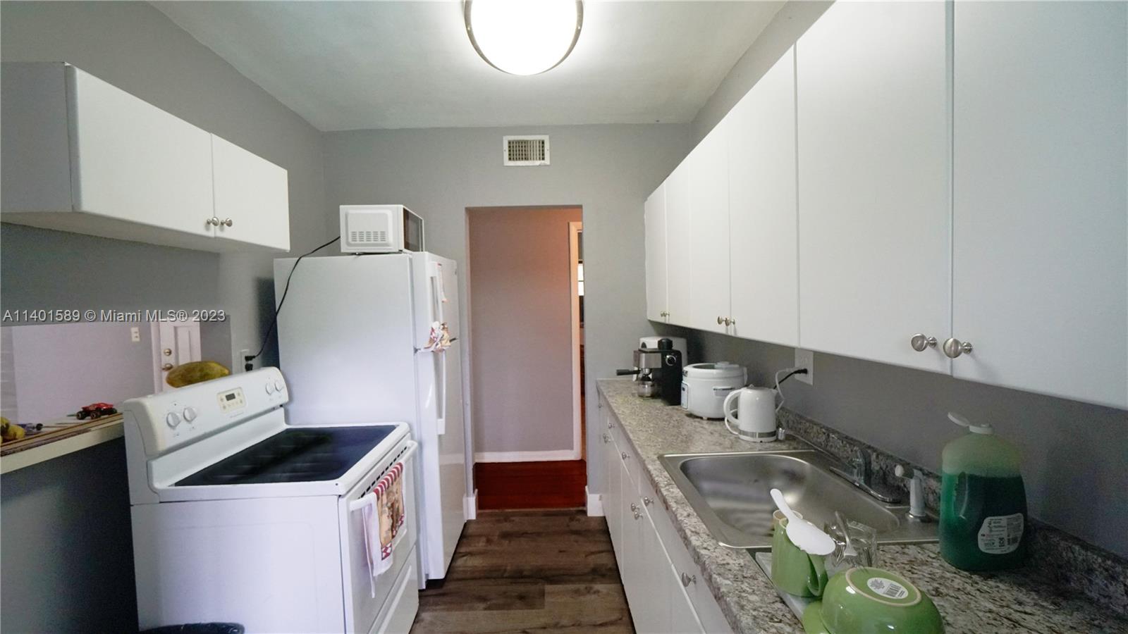 8480 Southwest 32nd Street Miami, FL 33155 - Photo 3 of 24 a kitchen with a refrigerator a stove and wooden cabinets