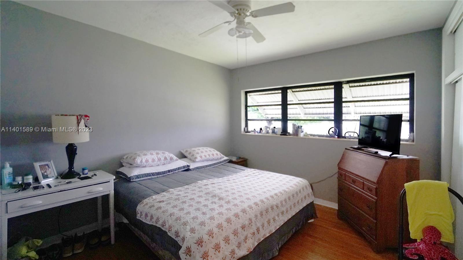 8480 Southwest 32nd Street Miami, FL 33155 - Photo 4 of 24 a bedroom with a bed and a flat screen tv