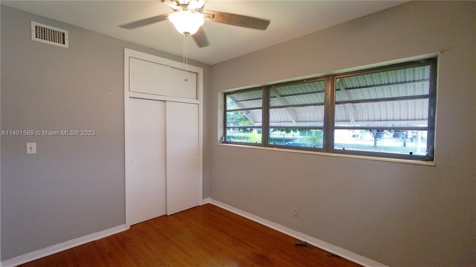 8480 Southwest 32nd Street Miami, FL 33155 - Photo 8 of 24 a view of an empty room with wooden floor and a window