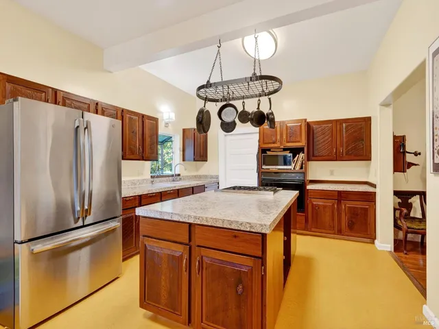 a kitchen with stainless steel appliances granite countertop a stove a refrigerator and a dining table