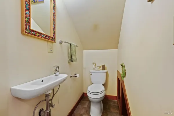 a bathroom with a toilet sink vanity and mirror