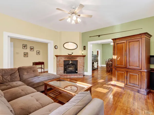 a view of a hallway with wooden floor and furniture