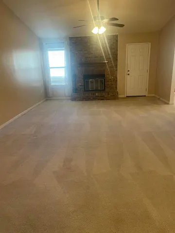 an empty room with windows and fireplace