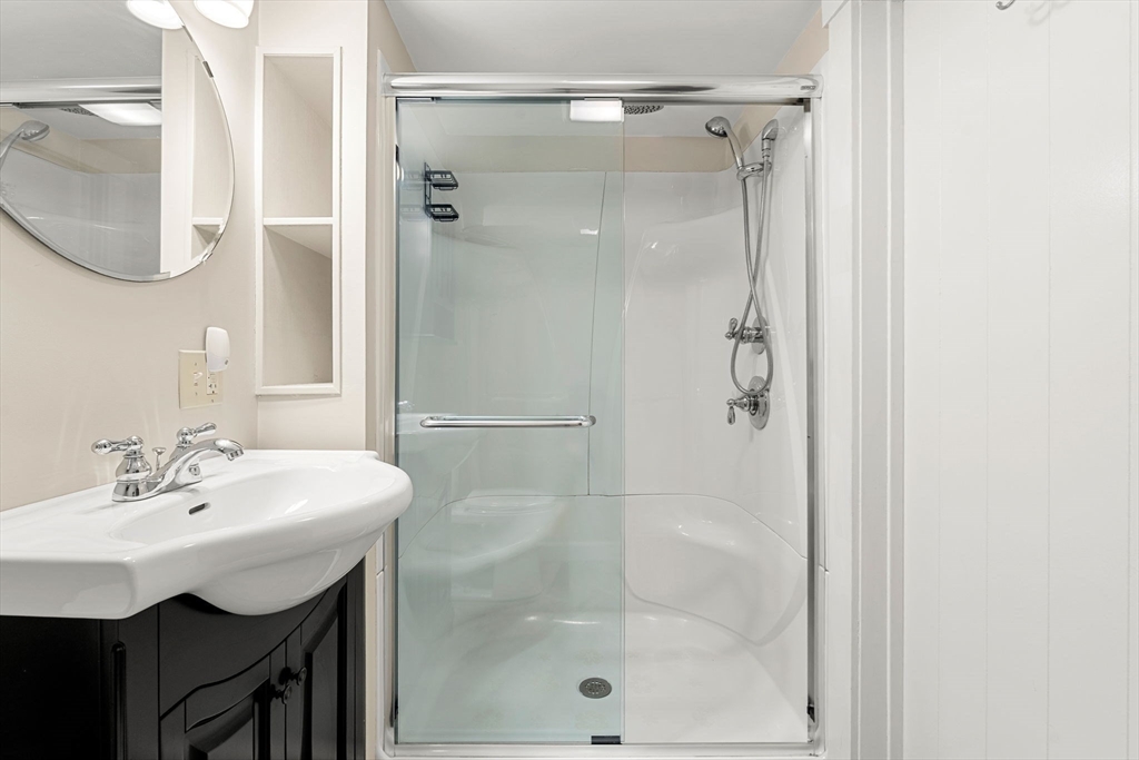 27 Hawthorn Road Milton, MA 02186 - Photo 20 of 26 a bathroom with a shower a sink and a mirror