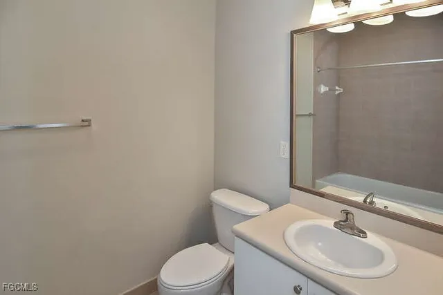 a bathroom with a toilet a sink and mirror