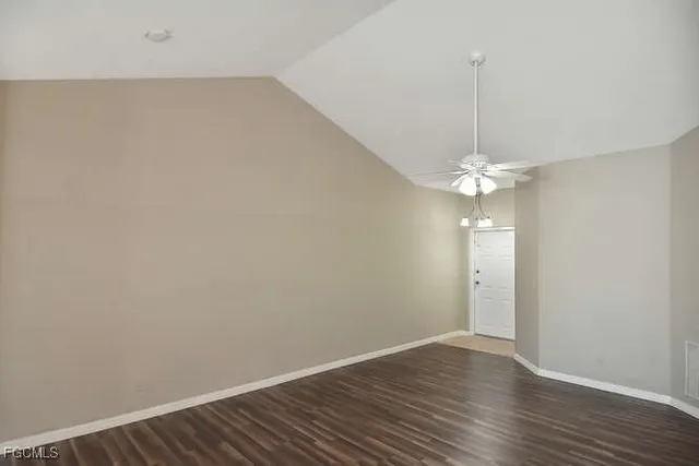 an empty room with wooden floor and ceiling fan