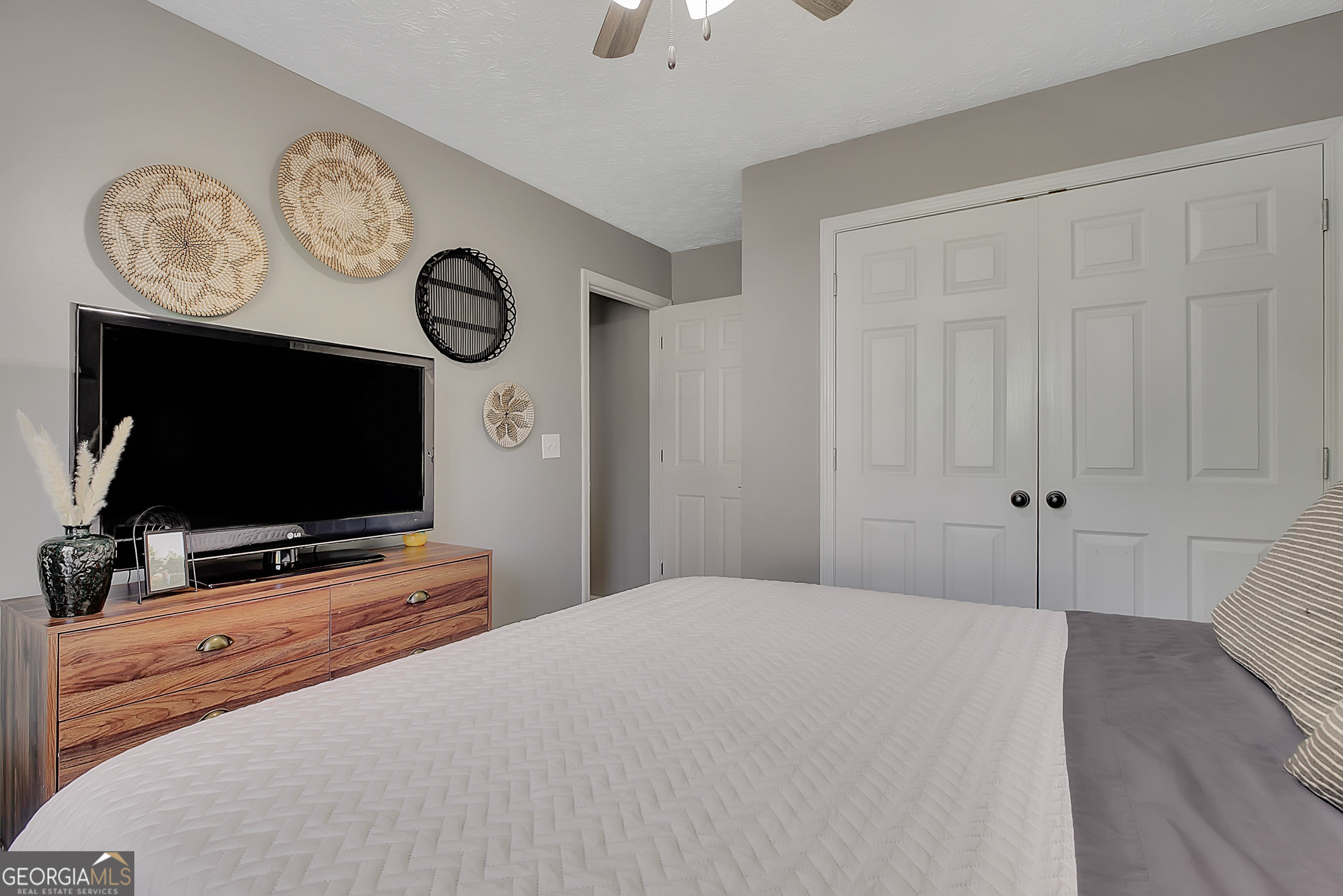 229 John Lovelace Road LaGrange, GA 30241 - Photo 11 of 59 a bedroom with a flat screen tv on wall and a clock
