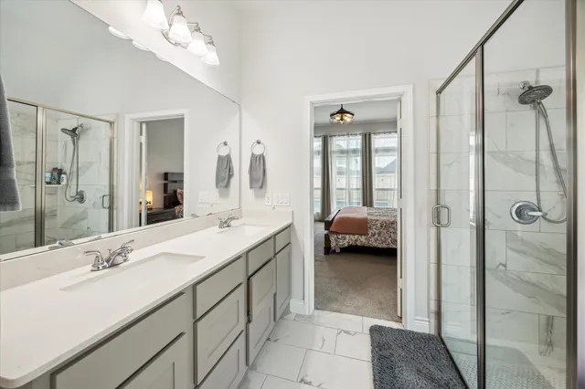 a en suite bathroom with a double vanity sink shower and mirror