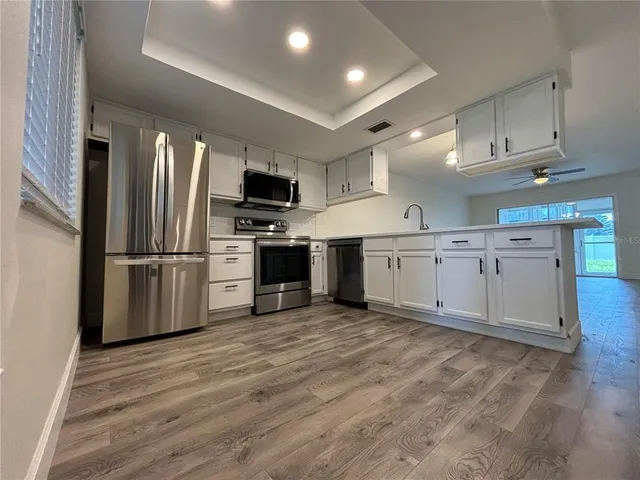 a kitchen with stainless steel appliances granite countertop a refrigerator sink and stove