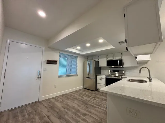 a kitchen with refrigerator and cabinets