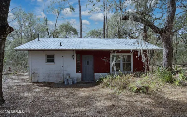 a view of a house with a yard and large tree