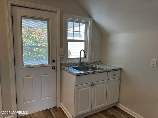 a kitchen with granite countertop a sink stove and cabinets