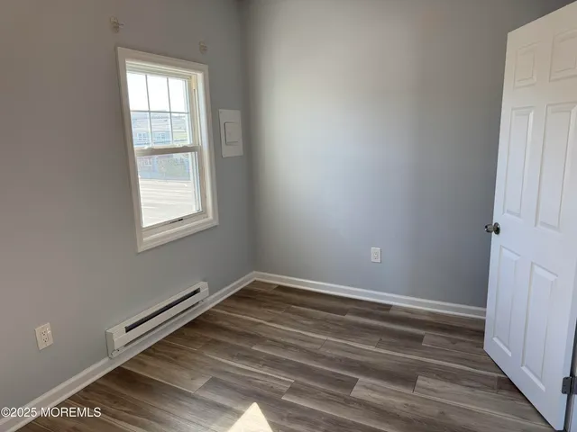 a view of a room with wooden floor and windows