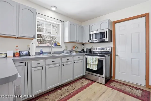a kitchen with a refrigerator and a wooden floor