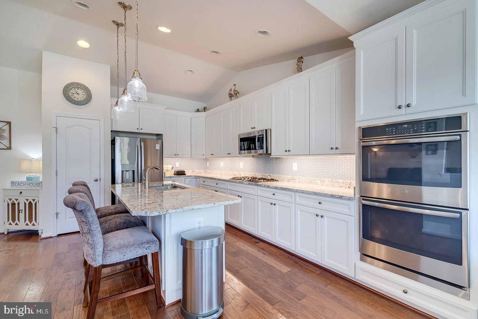 34438 Spring Brook Avenue Lewes, DE 19958 - Photo 14 of 58 a large kitchen with granite countertop lots of counter space dining table and stainless steel appliances