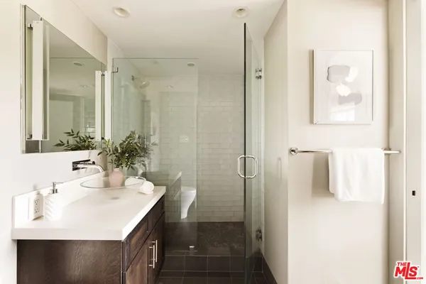 a bathroom with a sink a shower and a mirror