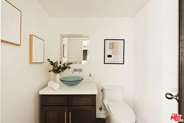 a bathroom with a toilet a sink and mirror