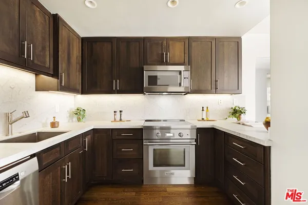 a kitchen with a sink a stove and cabinets