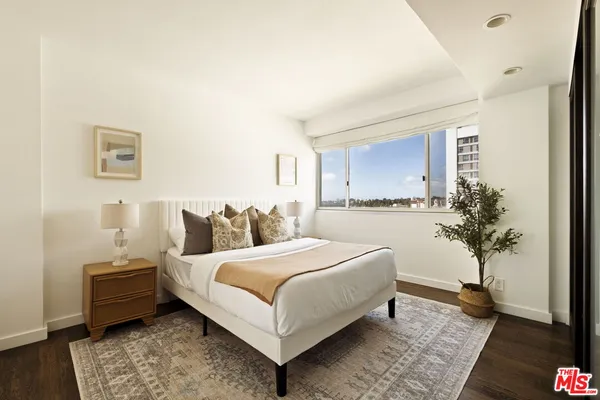 a bedroom with a bed and a potted plant