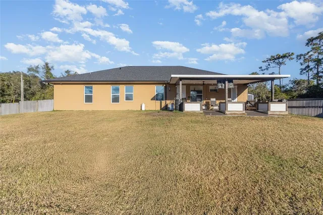 a view of a house with backyard and sitting area