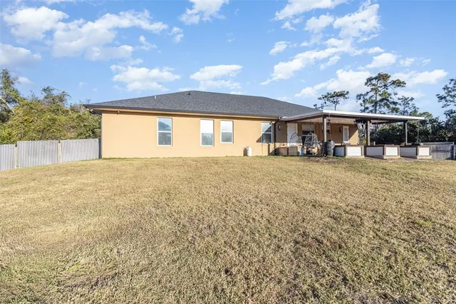a view of a house with a big yard and potted plants