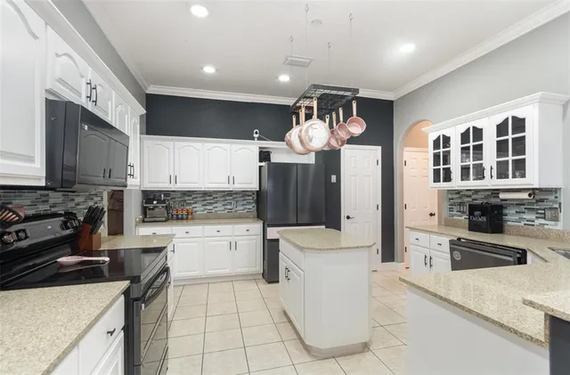 a kitchen with a sink a stove top oven and cabinets