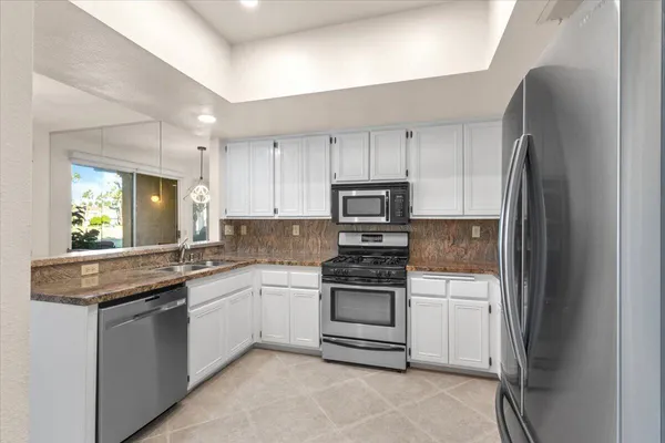 a kitchen with stainless steel appliances granite countertop a sink stove and refrigerator