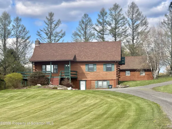 a front view of a house with a yard and trees