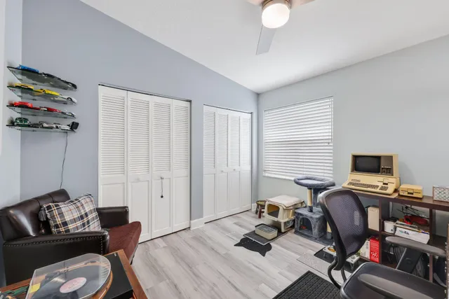 a living room with furniture a floor to ceiling window and a flat screen tv