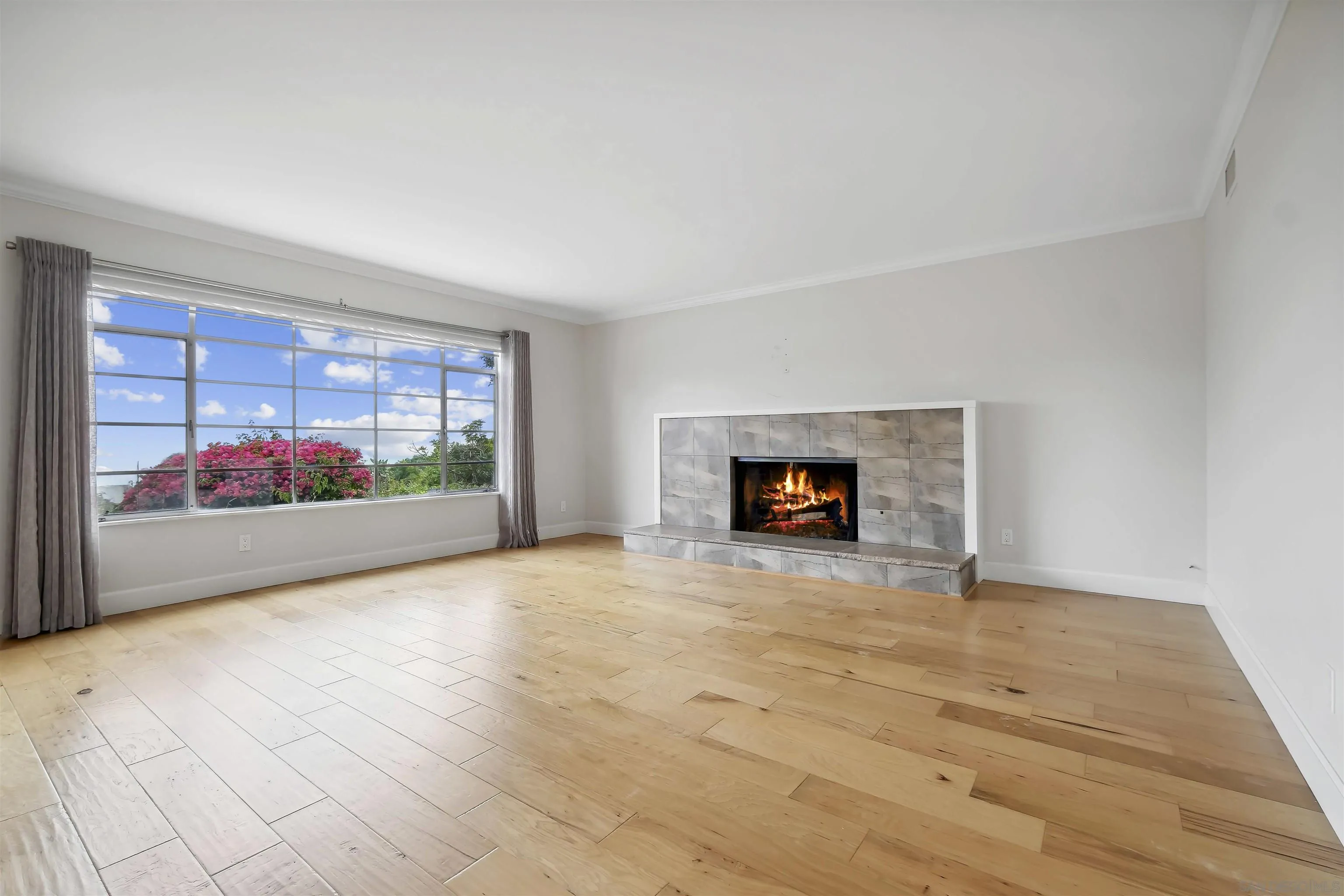 838 Lamplight Drive La Jolla, CA 92037 - Photo 11 of 42 a view of an empty room with a fireplace and a window