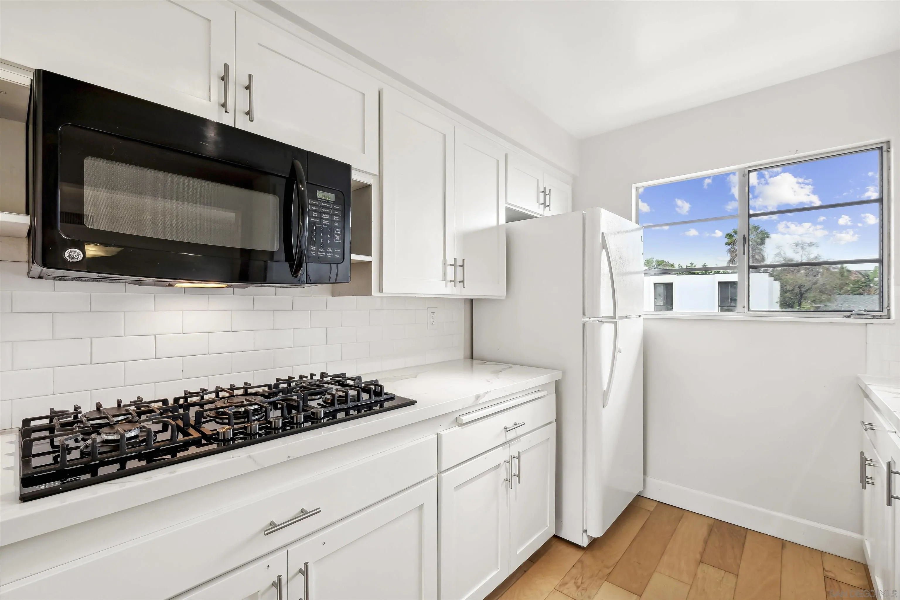 838 Lamplight Drive La Jolla, CA 92037 - Photo 19 of 42 a kitchen with a sink stove and microwave