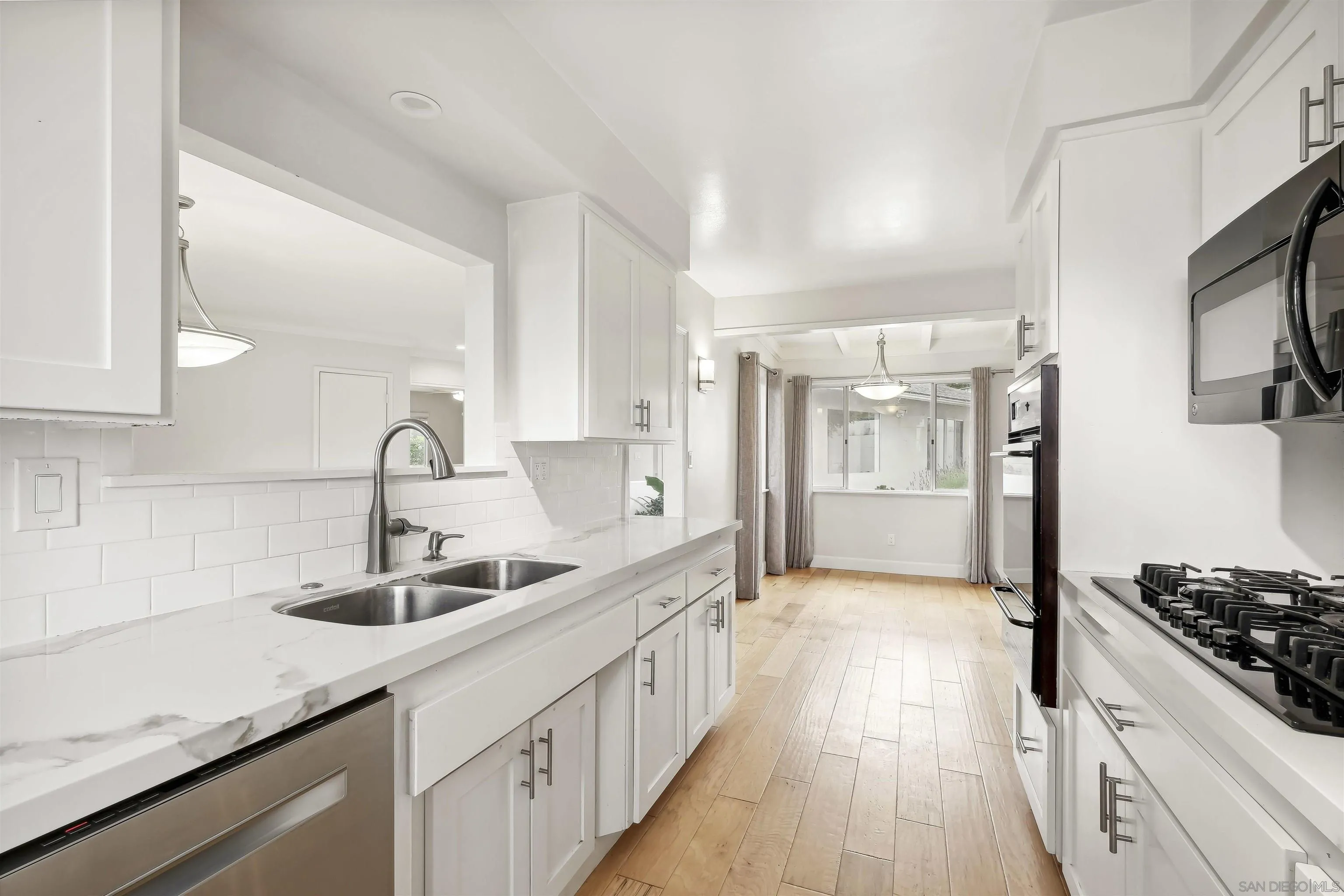 838 Lamplight Drive La Jolla, CA 92037 - Photo 21 of 42 a kitchen with sink a stove and cabinets