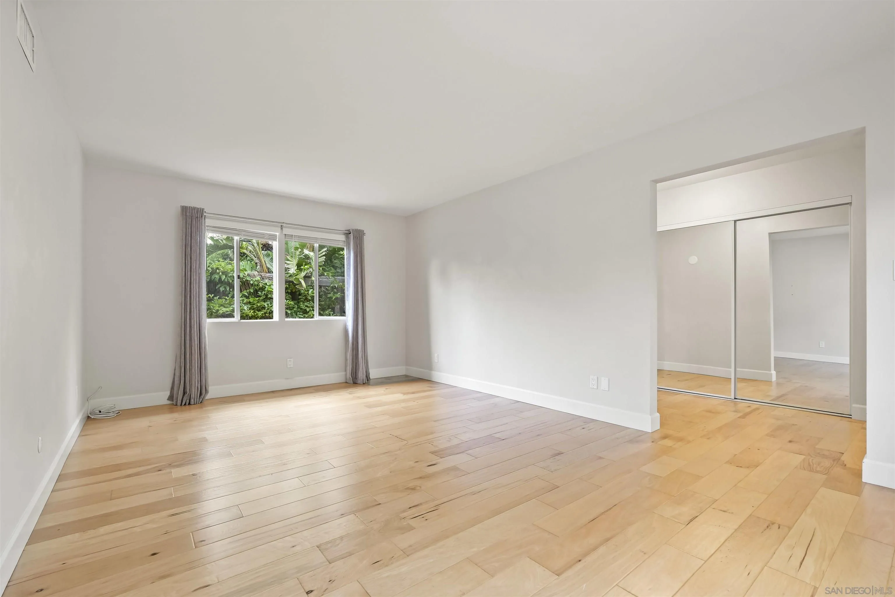 838 Lamplight Drive La Jolla, CA 92037 - Photo 24 of 42 an empty room with wooden floor and windows