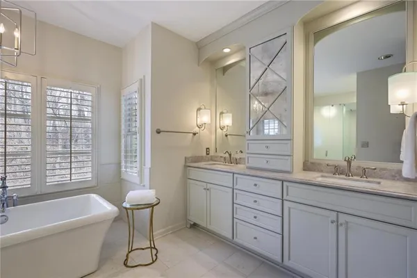 a bathroom with a granite countertop sink toilet a large mirror a bathtub and window