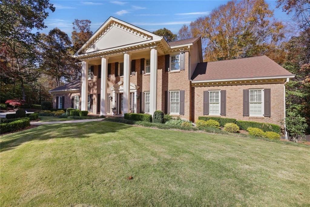 2080 Old Dominion Road Atlanta, GA 30350 - Photo 3 of 10 a view of a white house next to a yard with large trees