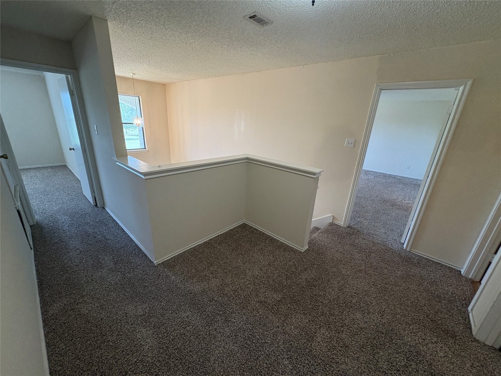 1367 Lakeside Loop Round Rock, TX 78665 - Photo 16 of 19 Hall featuring an upstairs landing, carpet, and a textured ceiling